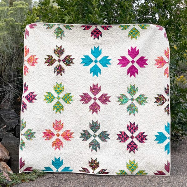 A colorful quilt with leaves on it.
