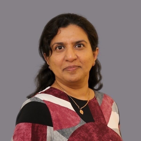 An indian woman in a maroon and grey top.