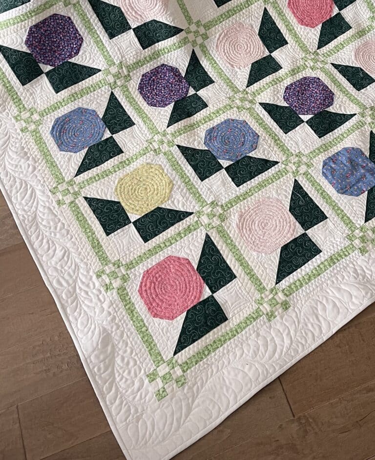 Flower quilt A quilt with colorful flowers on a wooden floor.