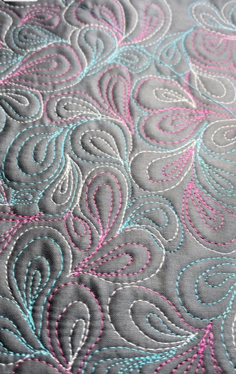 Colorful quilt with intricate stitching patterns.