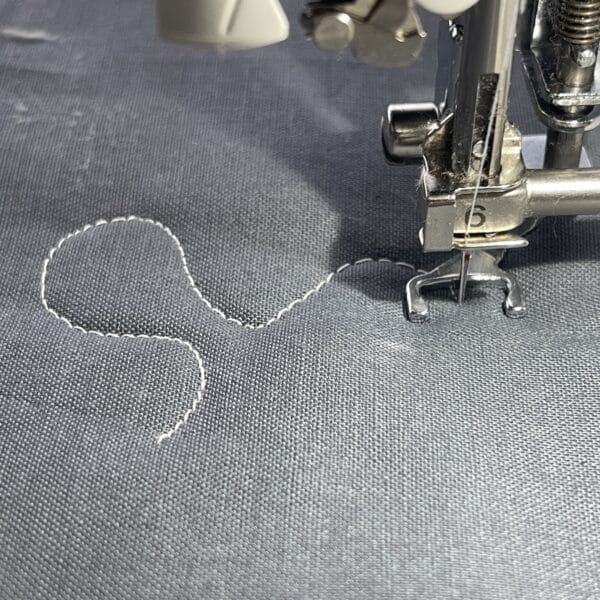 A sewing machine is being used to sew a piece of fabric.