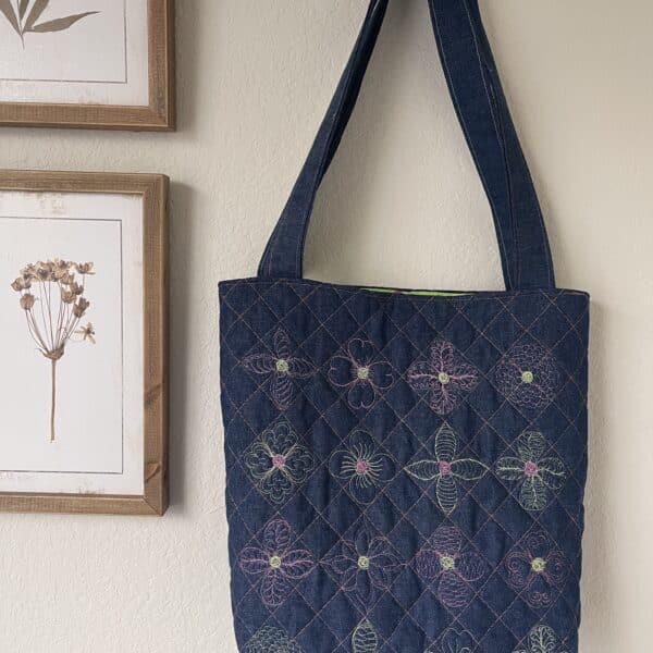 A blue quilted tote hanging on a wall.
