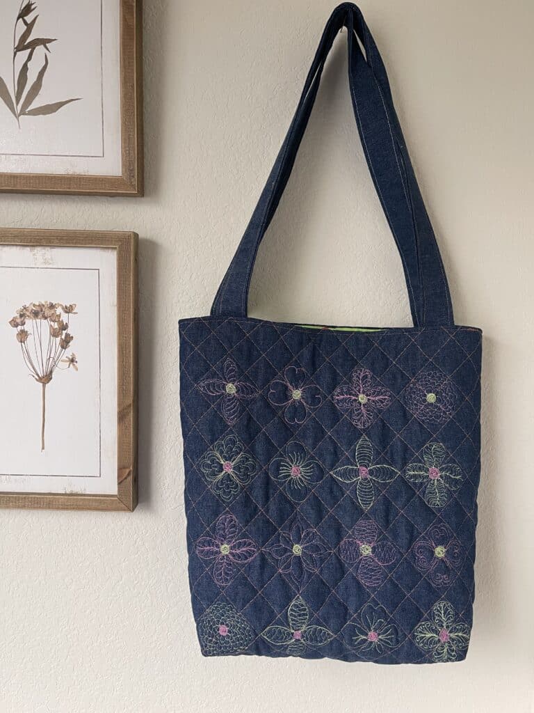 A blue quilted tote hanging on a wall.