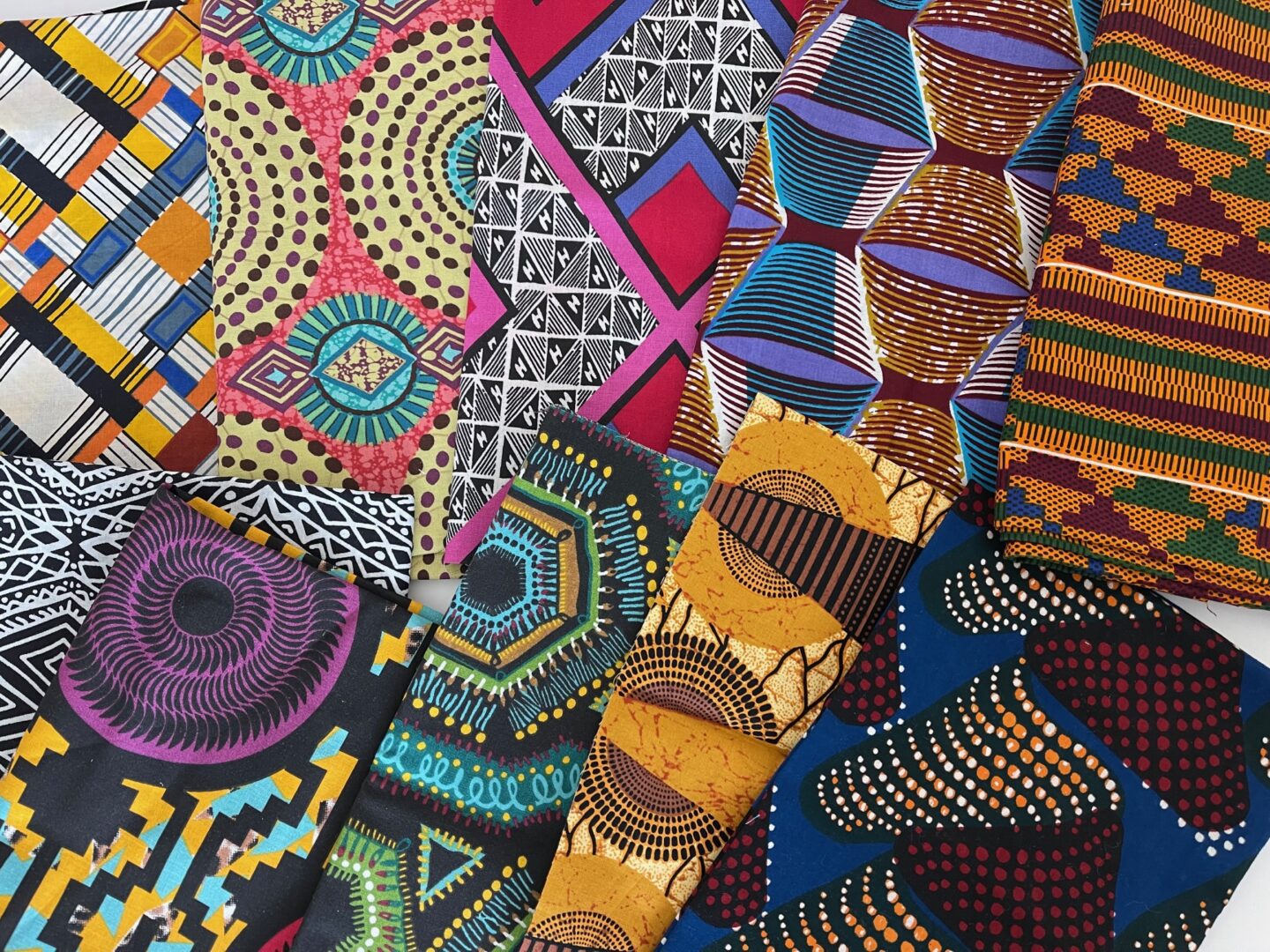 A collection of african print fabrics on a white surface.