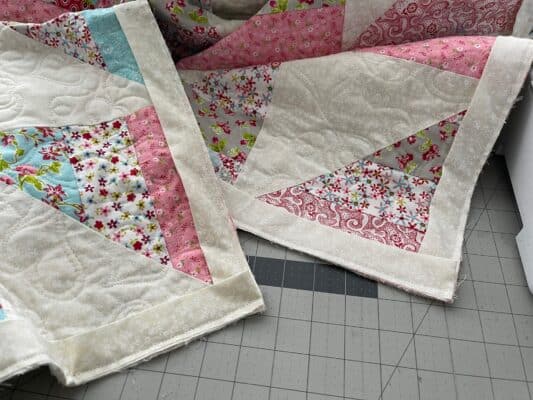A close up of two quilts on the floor