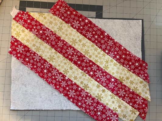 A red and white striped quilt with gold snowflakes.