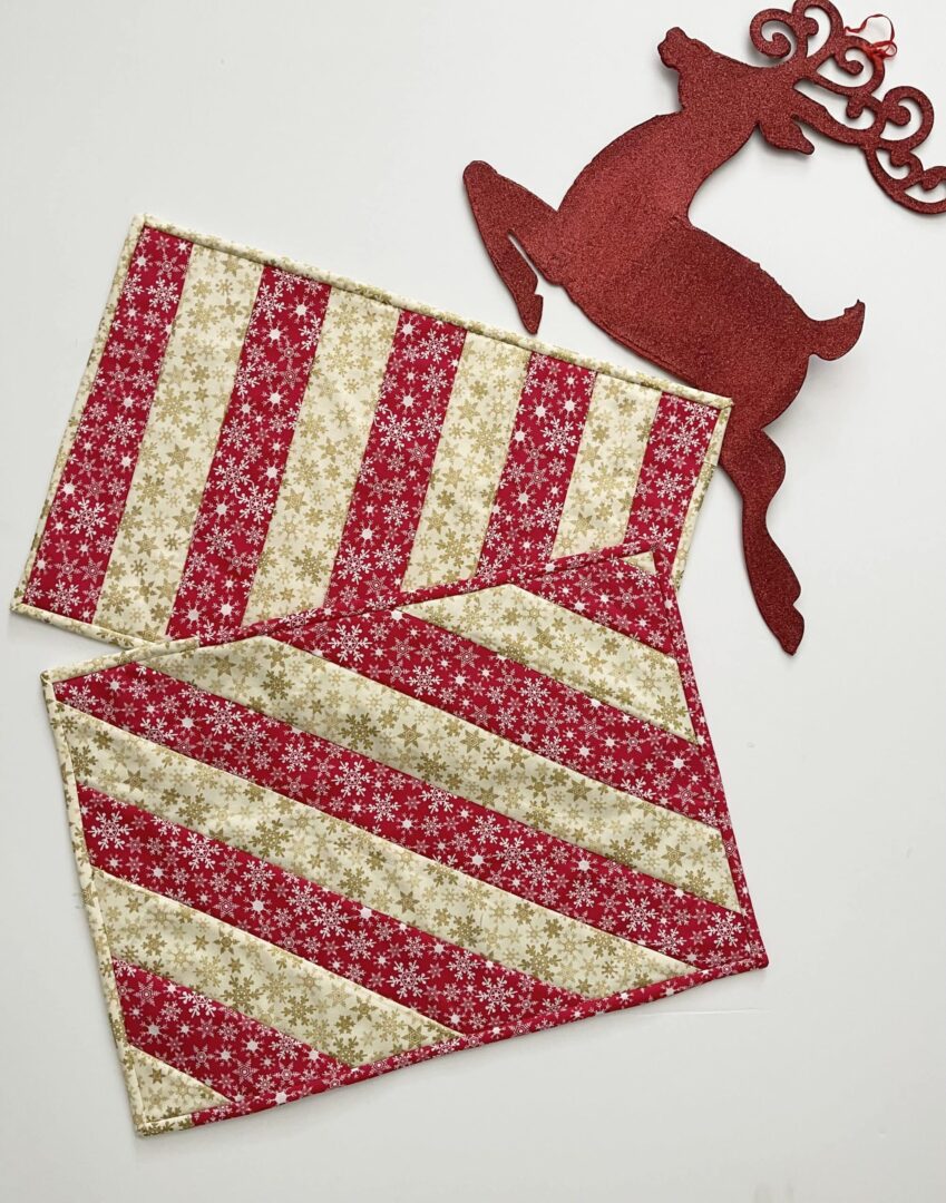A red and white striped quilt sitting on top of a table.