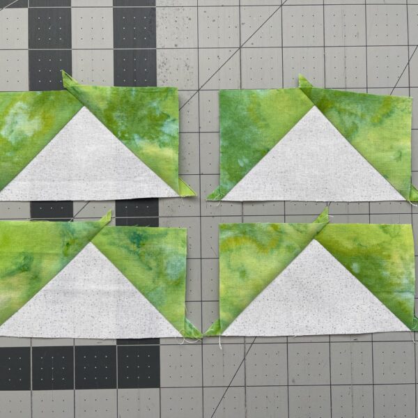 Four triangles on a cutting mat.