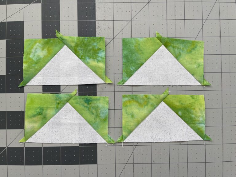 Four triangles on a cutting mat.