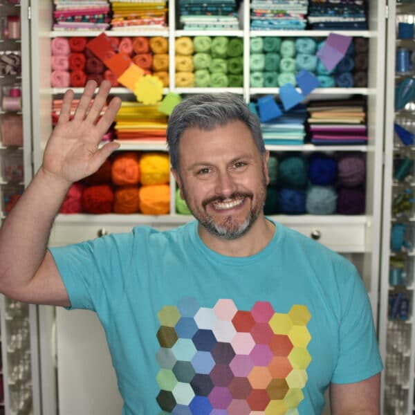 A man is standing in front of a room full of yarn.