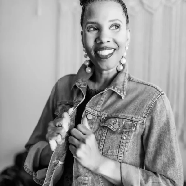 A black and white photo of a woman wearing a denim jacket.