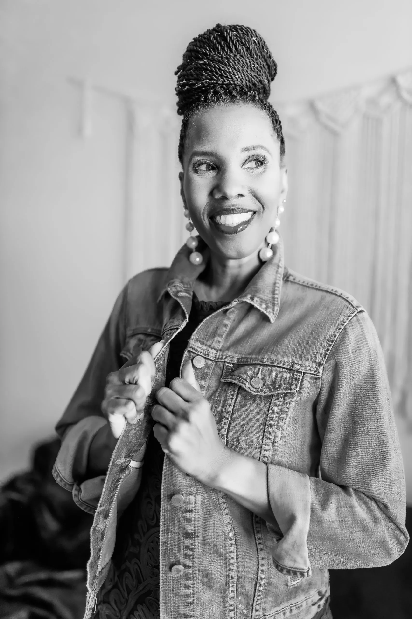A black and white photo of a woman wearing a denim jacket.