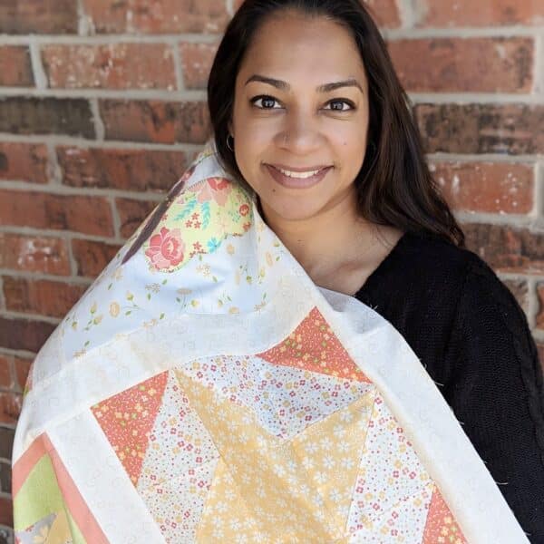 A woman holding onto a quilt over her head
