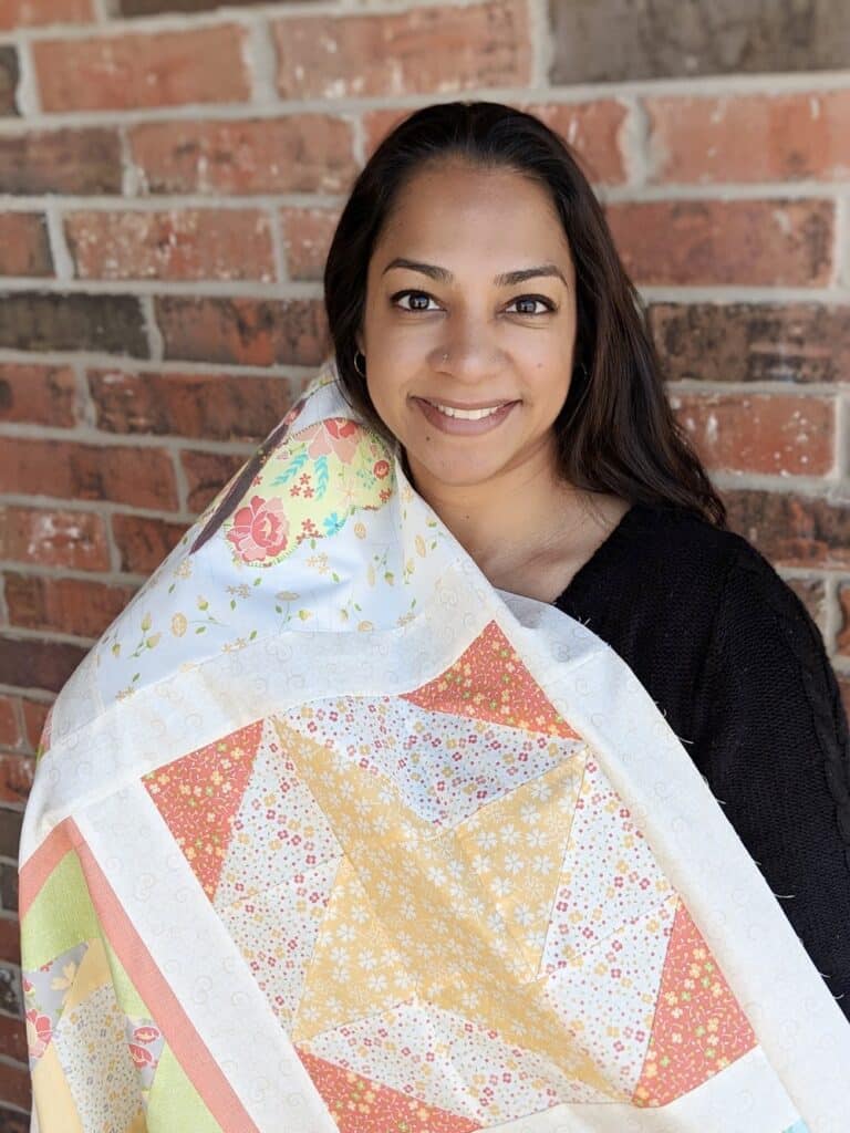 A woman holding onto a quilt over her head